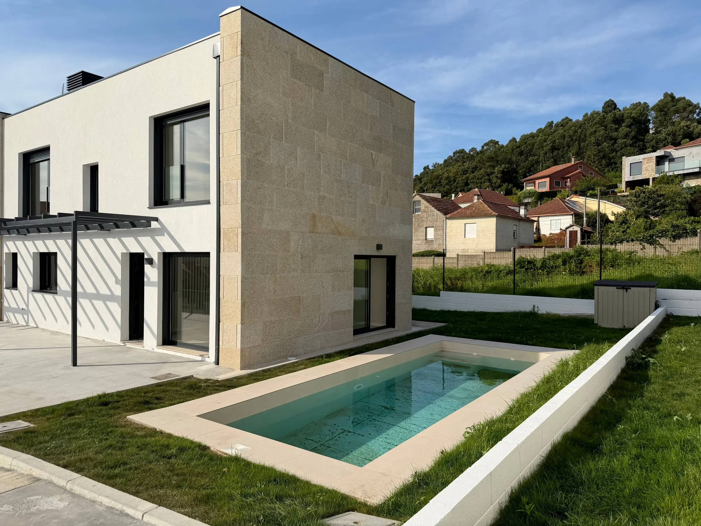 Una vivienda de Castrelos terminada: el testero de granito, el jardín y la piscina privada